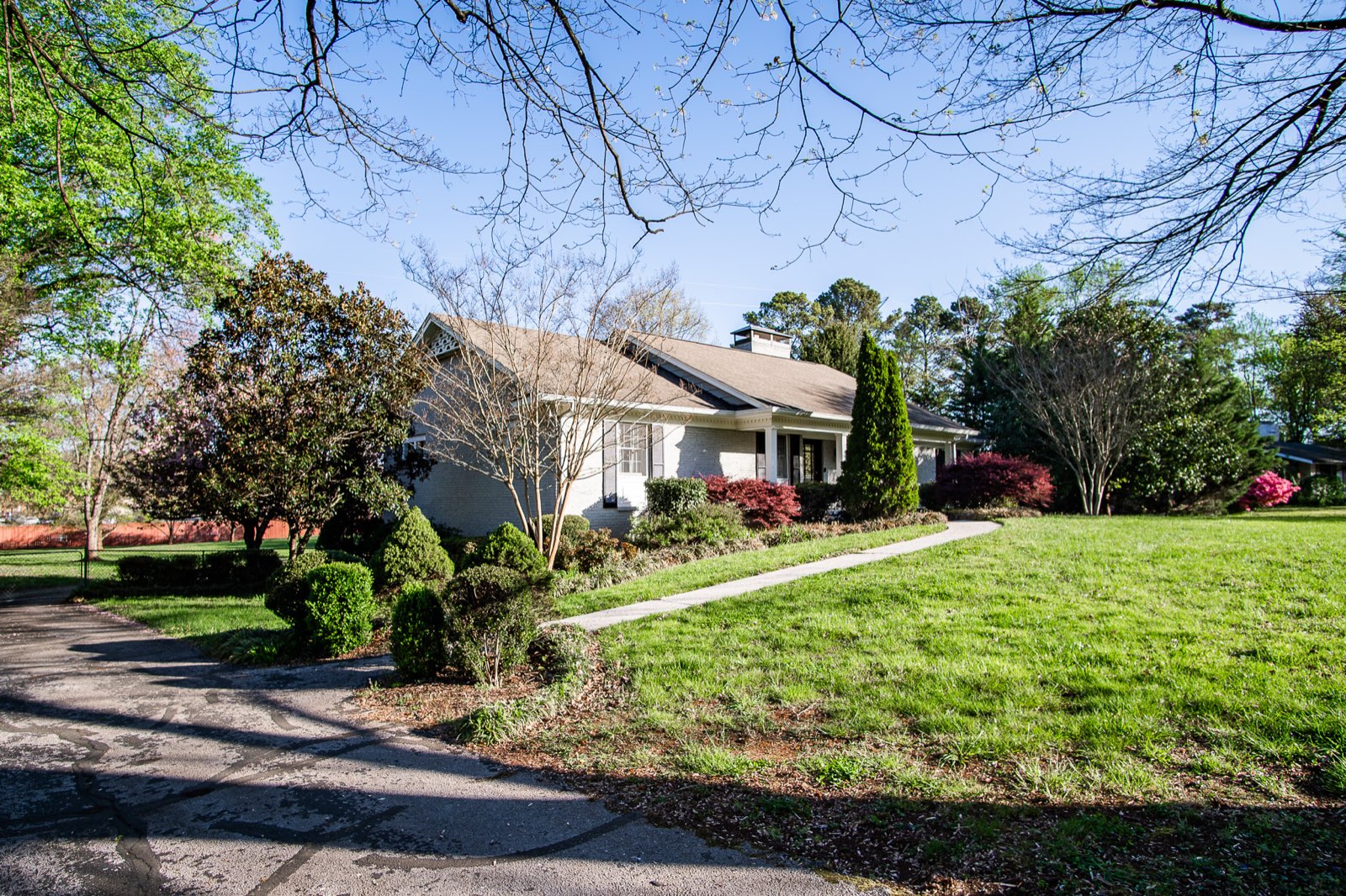 Brick ranch home with a big front lawn in spring